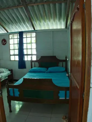 a bedroom with a bed with a wooden frame at Coco Encantado Eco Hostal Camping in Cartagena de Indias