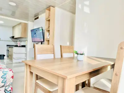 a dining room table with chairs and a tv at Sagitario apartment at 5 minutes from the beach and old city in Cartagena de Indias