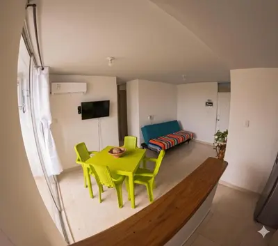 a living room with a yellow table and chairs at Apartamento Caribeño 1203 in Coveñas