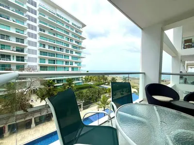 a balcony with a table and chairs and a view of a building at Morros 3, Beachfront & 2 Bedrooms in Cartagena de Indias