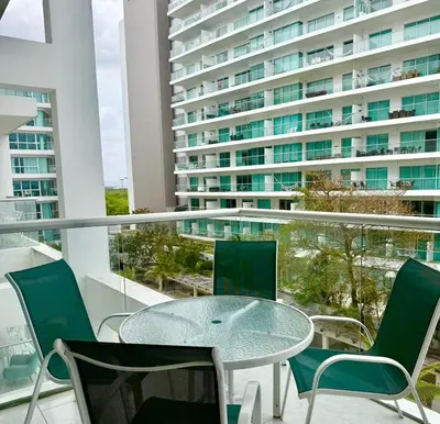 a glass table and chairs on a balcony with a large building at Morros 3, Beachfront & 2 Bedrooms in Cartagena de Indias