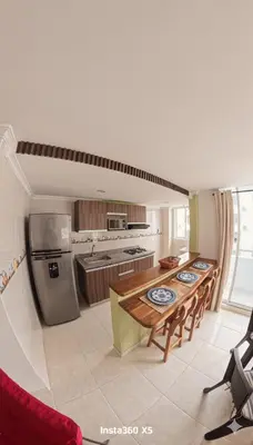 a large kitchen with a table and a refrigerator at Apartamento, Arena Dorada, Coveñas in Coveñas