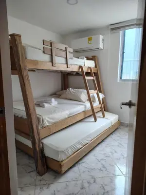 two bunk beds in a room with a window at Teca, Apto , Caribe in Coveñas