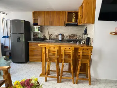a kitchen with a wooden table and a refrigerator at Teca, Apto , Caribe in Coveñas