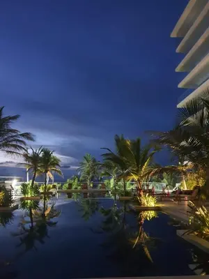 a resort with palm trees and a swimming pool at night at NOK Oceanside getaway in Cartagena in Cartagena de Indias