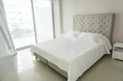 a white bedroom with a large bed and a large window at NOK Oceanside getaway in Cartagena in Cartagena de Indias