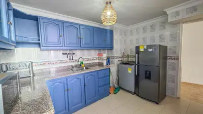 a kitchen with blue cabinets and a stainless steel refrigerator at Apt 3 rooms Laguito Cartagena 1 block from the beach in Cartagena de Indias