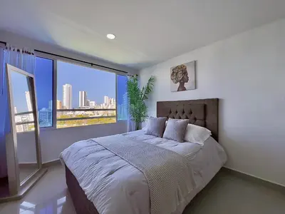 a bedroom with a large bed and a large window at Apto 894 in Cartagena de Indias