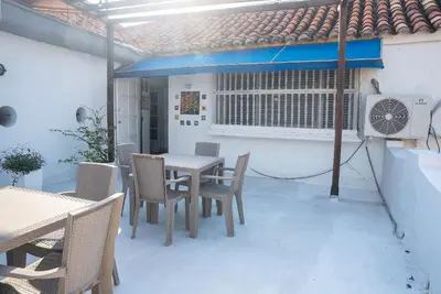 a patio with a table and chairs and a fan at Boutique Colonial en el Centro Histórico in Cartagena de Indias