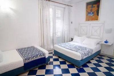 a bedroom with two beds and a checkered floor at Boutique Colonial en el Centro Histórico in Cartagena de Indias