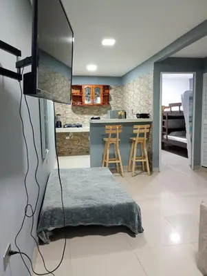 a living room with a television and a kitchen at Posada mary in Cartagena de Indias
