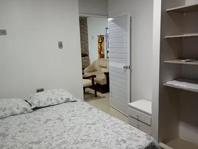 a bedroom with a bed and a closet and a chair at Posada mary in Cartagena de Indias