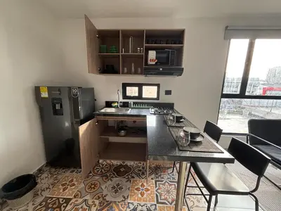 a small kitchen with a counter and a refrigerator at Suite Coral Tower in Barranquilla