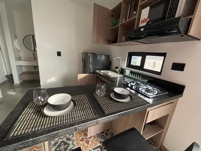 a kitchen with a counter with plates and glasses on it at Suite Coral Tower in Barranquilla