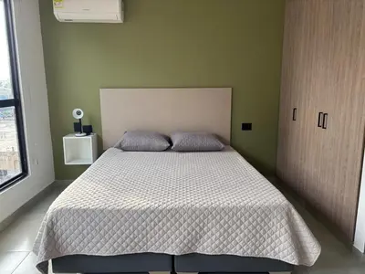 a bedroom with a bed with a white comforter at Suite Coral Tower in Barranquilla