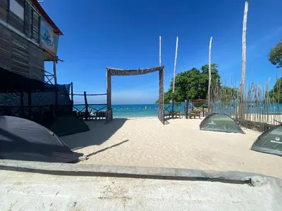 a beach with a swing set on the beach at Amora Beach Camping in Baru