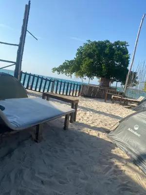 a picnic table on the beach next to the ocean at Amora Beach Camping in Baru