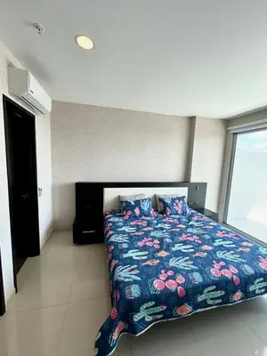 a bedroom with a bed with a colorful comforter at Apartamento con piscina gigante y acceso directo al mar in Cartagena de Indias