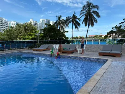 a woman standing next to a swimming pool at Lagoon & see view studio Cartagena in Cartagena de Indias