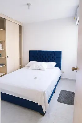 a bed with a blue headboard in a bedroom at Cartagena Apartamento completo vista al mar in Cartagena de Indias