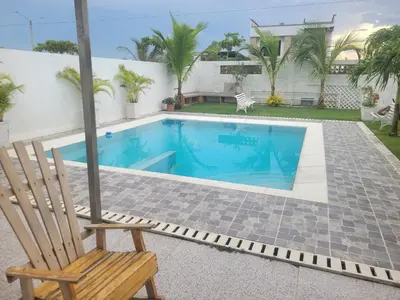 a chair sitting next to a swimming pool at Hostal Casa Adela