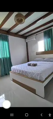 a bed in a bedroom with green curtains at Hostal Casa Adela