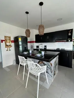 a kitchen with a table and two chairs and a dog laying on a counter at Acogedor apartamento con súper ubicación in Barranquilla