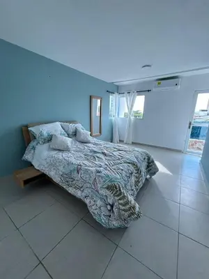 a bedroom with a bed and a blue wall at Acogedor apartamento con súper ubicación in Barranquilla