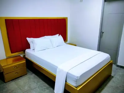 a bedroom with a large bed with a red headboard at Hotel La Dorada Sincelejo in Sincelejo