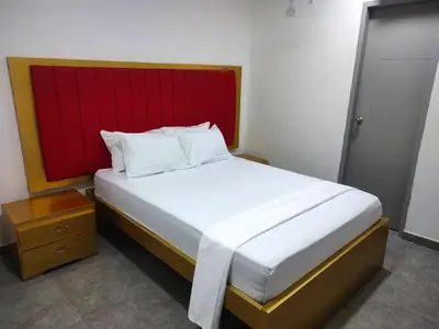 a bedroom with a large bed with a red headboard at Hotel La Dorada Sincelejo in Sincelejo