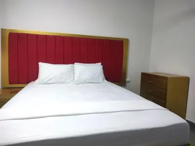 a large bed with a red headboard in a room at Hotel La Dorada Sincelejo in Sincelejo