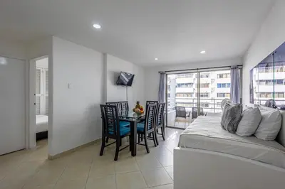 a bedroom with a bed and a table with chairs at Caribbean Paradise - Apartamento con salida directa a la playa in Cartagena de Indias