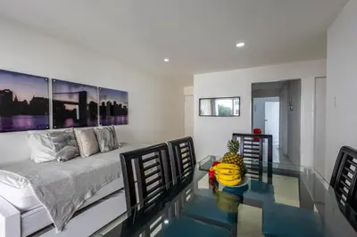 a bedroom with a bed and a glass table at Caribbean Paradise - Apartamento con salida directa a la playa in Cartagena de Indias