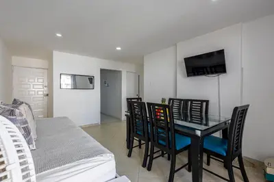 a dining room with a table and chairs and a bed at Caribbean Paradise - Apartamento con salida directa a la playa in Cartagena de Indias