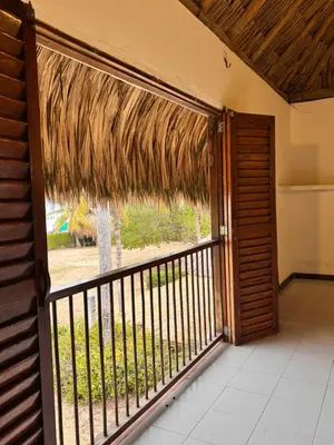 an open door to a balcony with a straw umbrella at Hostal nido tortuga in San Antero