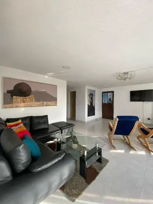 a living room with a black leather couch and chairs at White House in Cartagena de Indias