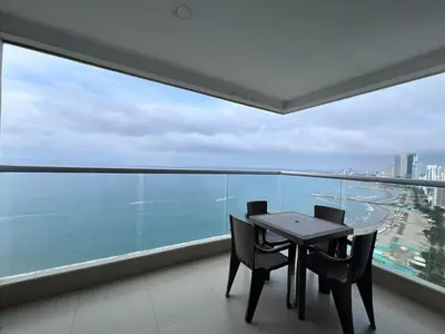 a table and chairs in a balcony with a view of the ocean at Azurea Beach in Cartagena de Indias