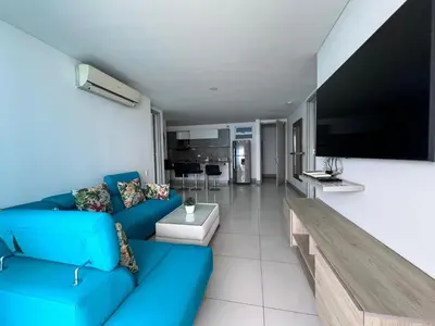 a living room with a blue couch and a flat screen tv at Azurea Beach in Cartagena de Indias