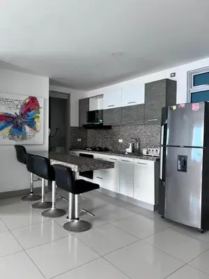 a kitchen with a refrigerator and a table and chairs at Azurea Beach in Cartagena de Indias