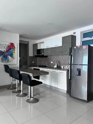 a kitchen with a refrigerator and a table and chairs at Azurea Beach in Cartagena de Indias
