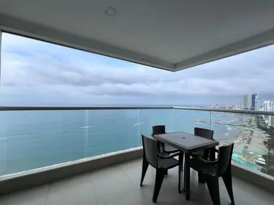 a table and chairs in a balcony with a view of the ocean at Azurea Beach in Cartagena de Indias
