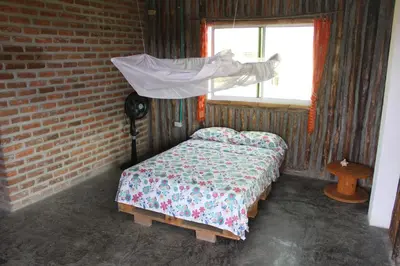 a bedroom with a bed in a brick wall at Casa Grulla in Santa Marta