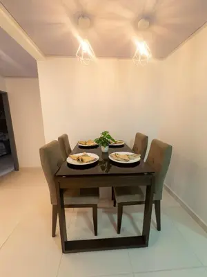 a dining room table with chairs and plates of food at CALA Estancias Urbanas, Apartamentos & Suites in Barranquilla