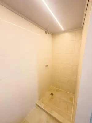 a bathroom with white walls and a shower at CALA Estancias Urbanas, Apartamentos & Suites in Barranquilla