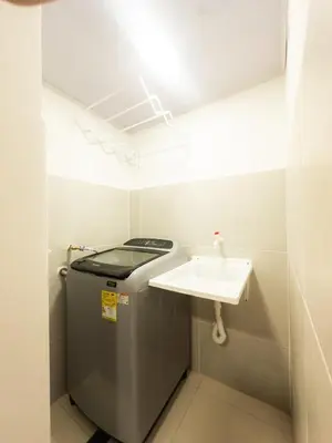 a small bathroom with a sink and a washing machine at CALA Estancias Urbanas, Apartamentos & Suites in Barranquilla
