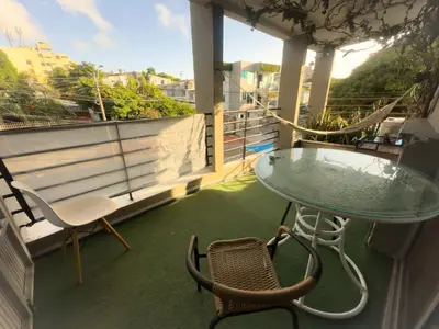 a balcony with a glass table and chairs at CALA Estancias Urbanas, Apartamentos & Suites in Barranquilla
