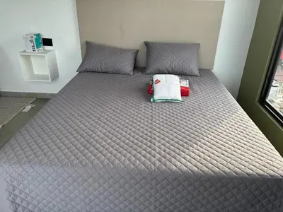 a large bed in a room with a gray blanket at Delux Suite Coral Tower in Barranquilla