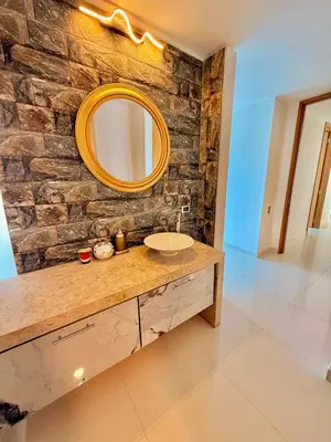 a bathroom with a sink and a mirror on a stone wall at Karibmed Cartagena in Cartagena de Indias