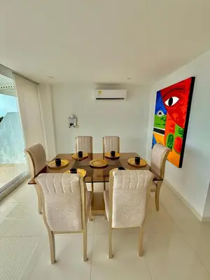 a dining room with a wooden table and chairs at Karibmed Cartagena in Cartagena de Indias