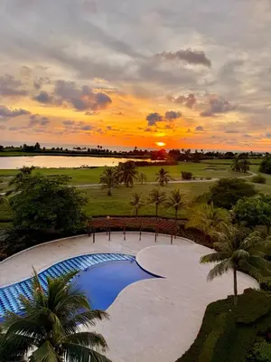 a sunset over a swimming pool at a resort at Karibmed Cartagena in Cartagena de Indias